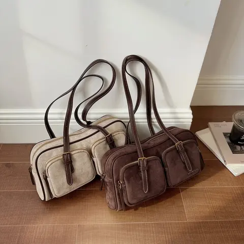 Two suede shoulder bags, one cream and one brown, with long leather handles