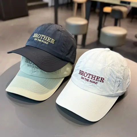 Navy and white baseball caps with embroidered lettering on the front panel