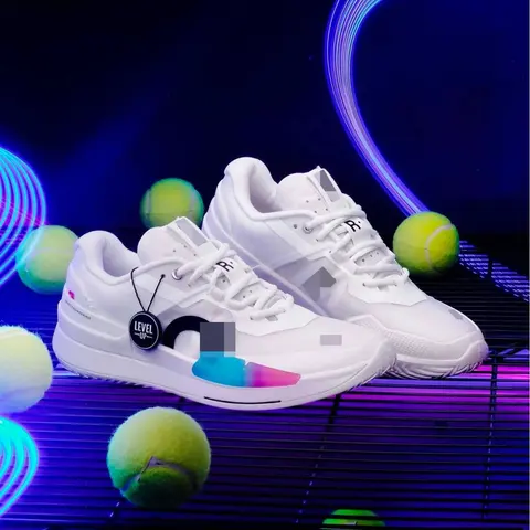 White low-top court shoes with a colour-fade heel, set among tennis balls under neon light