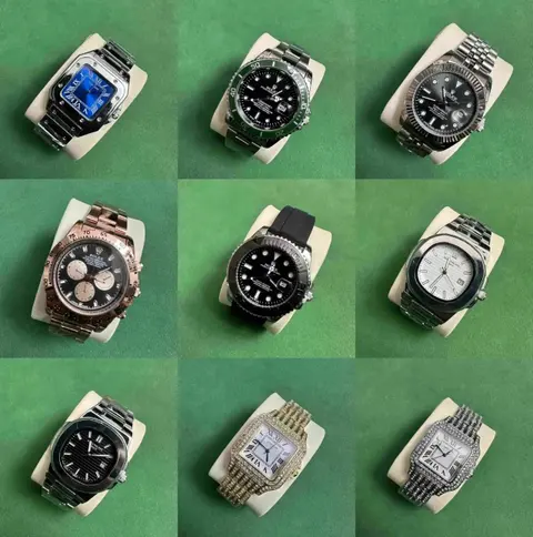 Nine steel wristwatches with dark and light dials on a green backdrop